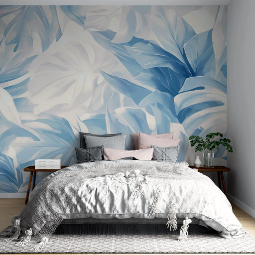 Une chambre apaisante avec un papier peint tropical aux grandes feuilles bleu clair et blanc créant une atmosphère fraîche et relaxante.