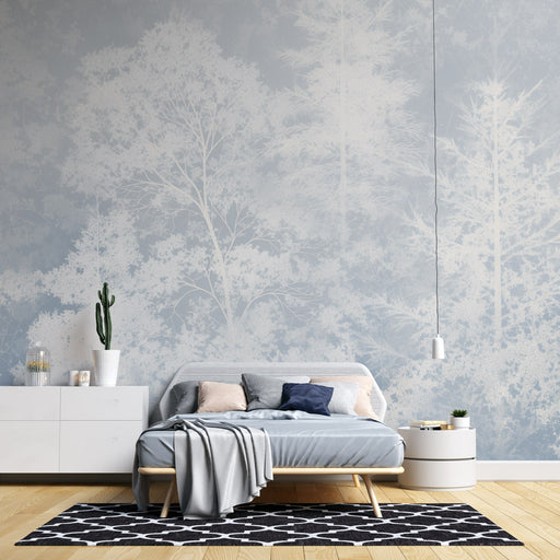 Une chambre apaisante avec un papier peint représentant des arbres en silhouette blanche sur fond bleu clair, créant une atmosphère naturelle et sereine.
