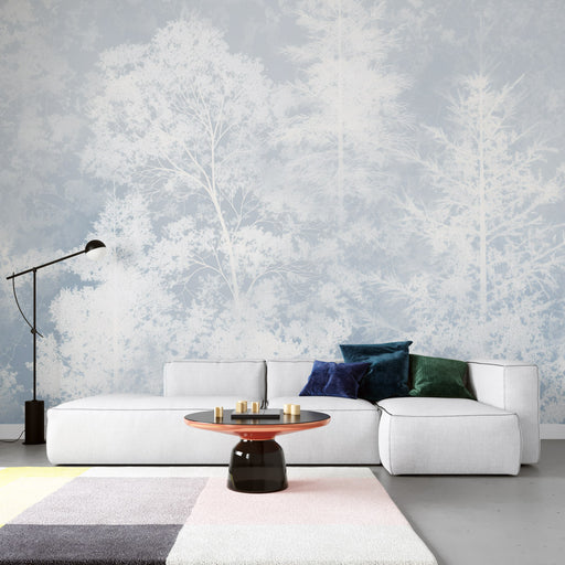 Un salon moderne avec un papier peint représentant des arbres en silhouettes blanches sur fond bleu clair, créant une ambiance apaisante et naturelle.