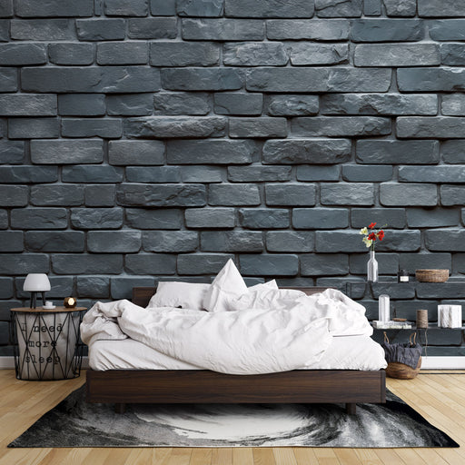 Une chambre moderne avec un papier peint en briques grises texturées créant une ambiance industrielle et chaleureuse.