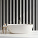 Une salle de bain moderne avec un papier peint à rayures noires et blanches créant une ambiance chic et graphique.