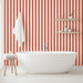 Une salle de bain moderne avec un papier peint à rayures rouges et blanches créant une ambiance dynamique et chaleureuse.