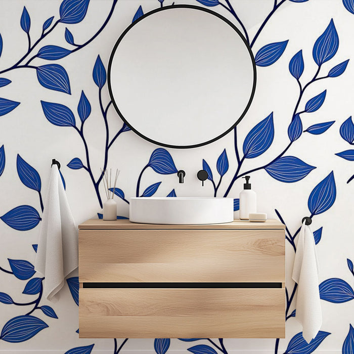 Une salle de bain moderne avec un papier peint aux motifs de feuilles bleu vif sur fond blanc, créant une ambiance fraîche et apaisante.
