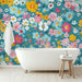 Une salle de bain lumineuse avec un papier peint floral aux motifs colorés sur fond turquoise, créant une ambiance joyeuse et rafraîchissante.