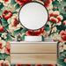 Une salle de bain moderne avec un papier peint floral aux grandes fleurs rouges et blanches sur fond vert, créant une ambiance chaleureuse et accueillante.