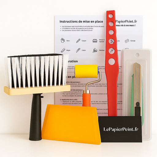 L'image présente des outils de pose de papier peint, incluant un rouleau, une brosse, un cutter et une raclette, évoquant une ambiance pratique et créative pour les amateurs de décoration.