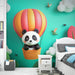 Papier peint chambre enfant avec panda mignon dans une montgolfière colorée et nuages pour décoration ludique.