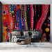 Un salon moderne avec un papier peint abstrait aux couleurs vives et dynamiques, mêlant des formes circulaires sur fond noir, créant une ambiance artistique et énergique.