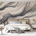 Une chambre élégante avec un papier peint abstrait aux nuances de beige et noir, évoquant des vagues fluides et une atmosphère apaisante.
