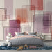 Une chambre moderne avec un papier peint abstrait aux formes géométriques en dégradés de rose et violet, créant une atmosphère artistique et apaisante.