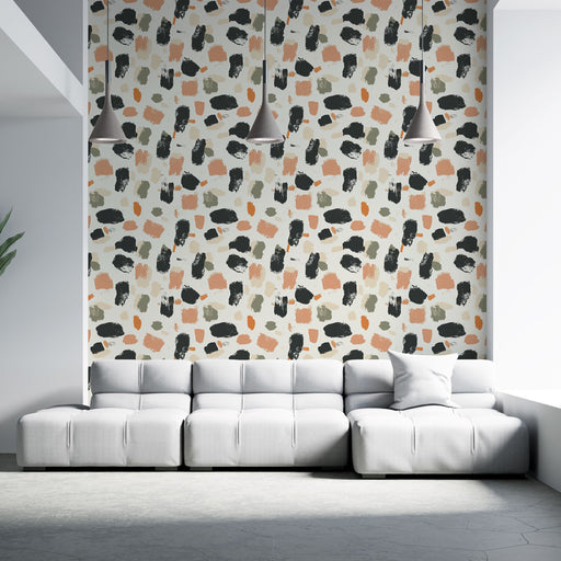 Un salon contemporain avec un papier peint abstrait aux motifs colorés dans des teintes de noir, beige, vert et terracotta, créant une ambiance dynamique et artistique.
