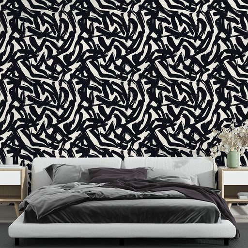 Une chambre moderne avec un papier peint abstrait noir et blanc aux motifs dynamiques, créant une ambiance artistique et contemporaine.