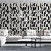 Un salon moderne avec un papier peint abstrait noir et beige aux motifs de coups de pinceau, créant une ambiance artistique et dynamique.