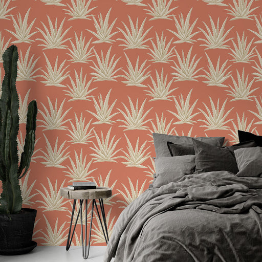 Une chambre moderne avec un papier peint terracotta orné de motifs d'agaves blancs, créant une atmosphère chaleureuse et accueillante.