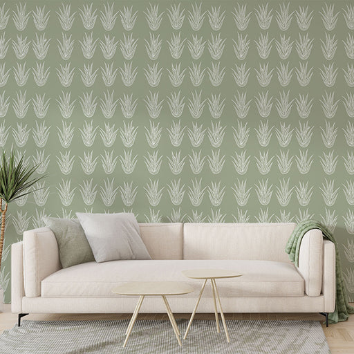 Un salon moderne avec un papier peint vert doux orné de motifs de plantes graphiques blanches, créant une ambiance naturelle et apaisante.