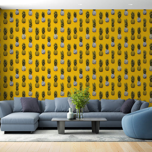 Un salon moderne avec un papier peint jaune vif orné de motifs d'ananas noirs et blancs, créant une ambiance joyeuse et estivale.