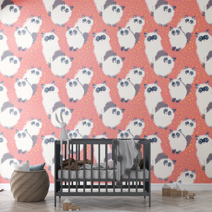 Une chambre d'enfant avec un papier peint ludique représentant des chats aux yeux expressifs sur un fond rose parsemé de petites taches jaunes, créant une ambiance joyeuse et chaleureuse.
