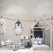 Une chambre d'enfant avec un papier peint illustrant des animaux mignons suspendus, sur fond beige, créant une atmosphère douce et ludique.
