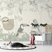 Une chambre d'enfant avec un papier peint illustré de faune tropicale, représentant des animaux ludiques sur fond clair, créant une atmosphère joyeuse et accueillante.
