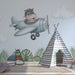 Une chambre d'enfant avec un papier peint illustratif représentant un hippopotame joyeux dans un avion, créant une ambiance ludique et imaginative.