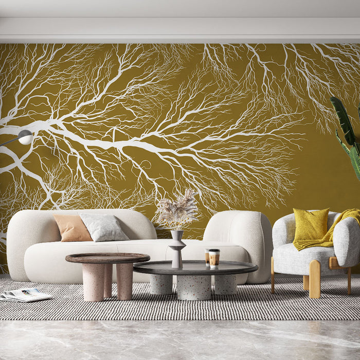 Un salon moderne avec un papier peint aux motifs d'arbres blancs sur fond moutarde, créant une ambiance chaleureuse et organique.