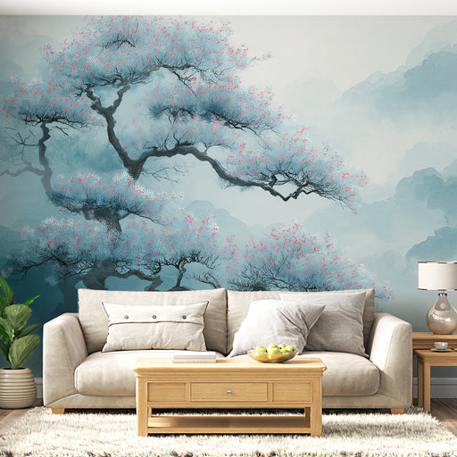 Un salon lumineux avec un papier peint représentant un arbre aux fleurs roses sur fond bleu, créant une atmosphère apaisante et poétique.