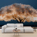 Un salon moderne avec un papier peint représentant un arbre aux fleurs blanches et dorées sur fond bleu nuit, créant une atmosphère douce et apaisante.