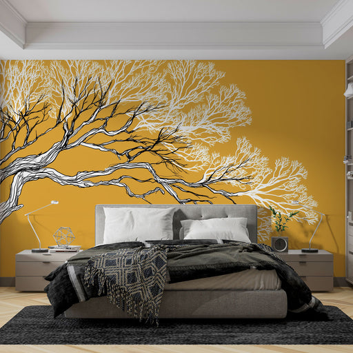 Une chambre moderne avec un papier peint jaune vif représentant des branches d'arbre en noir et blanc, créant une atmosphère à la fois chaleureuse et artistique.