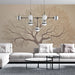 Un salon moderne avec un papier peint représentant un grand arbre aux branches délicates et aux feuilles stylisées, créant une atmosphère apaisante et naturelle.