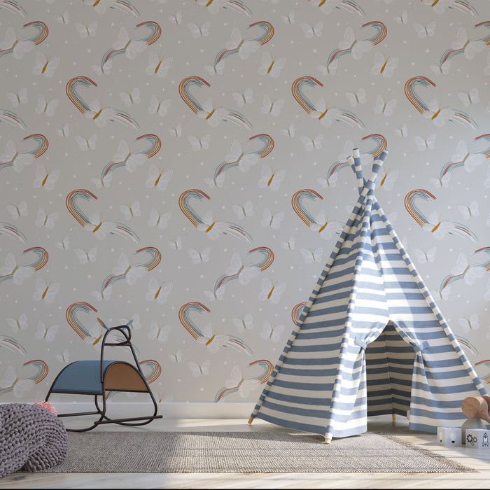 Une chambre d'enfant avec un papier peint ludique illustrant des arcs-en-ciel colorés et des papillons sur fond gris, créant une atmosphère joyeuse et rêveuse.