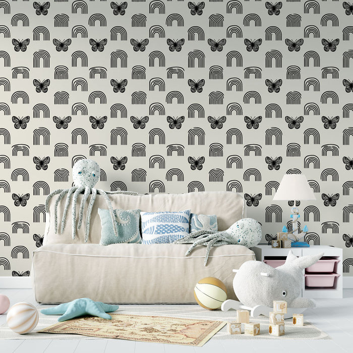 Un salon accueillant avec un papier peint ludique représentant des arcs-en-ciel noirs et des papillons sur fond clair, créant une atmosphère joyeuse et dynamique.