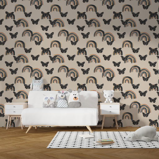 Une chambre d'enfant avec un papier peint ludique représentant des arcs-en-ciel colorés et des papillons noirs sur fond beige, créant une ambiance joyeuse et accueillante.