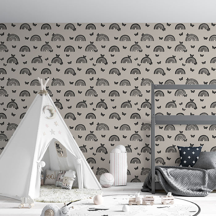 Une chambre d'enfant avec un papier peint beige orné de motifs de arcs-en-ciel et de papillons noirs, créant une atmosphère joyeuse et ludique.