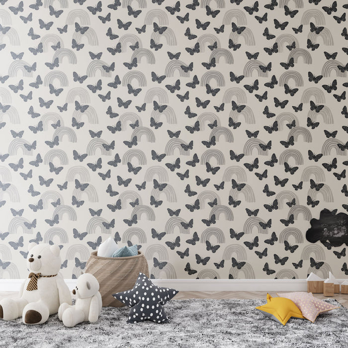 Une chambre d'enfant avec un papier peint illustrant des arcs-en-ciel et des papillons gris sur fond clair, créant une ambiance douce et rêveuse.