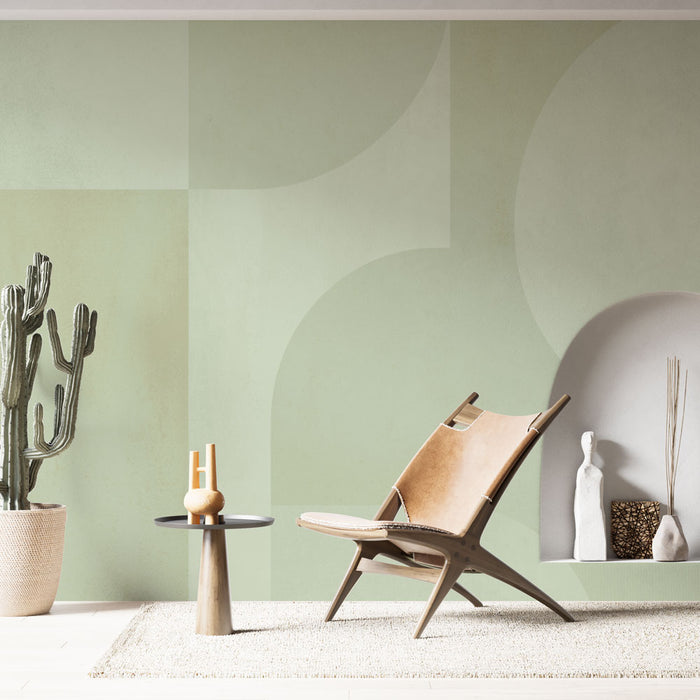Une pièce moderne avec un papier peint aux formes géométriques douces dans des teintes vertes apaisantes, créant une atmosphère sereine et minimaliste.