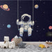 Papier peint espace avec astronaute se balançant et planètes colorées pour chambre d'enfant.