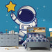 Papier peint chambre enfant avec astronaute tenant une étoile brillante dans l'espace, idéal pour décoration murale.