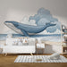 Une chambre d'enfant avec un papier peint illustratif représentant une baleine bleue nageant sous un ciel nuageux, créant une ambiance ludique et apaisante.