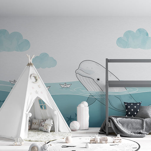 Une chambre d'enfant avec un papier peint illustrant une baleine sur fond aquatique, créant une atmosphère douce et ludique.