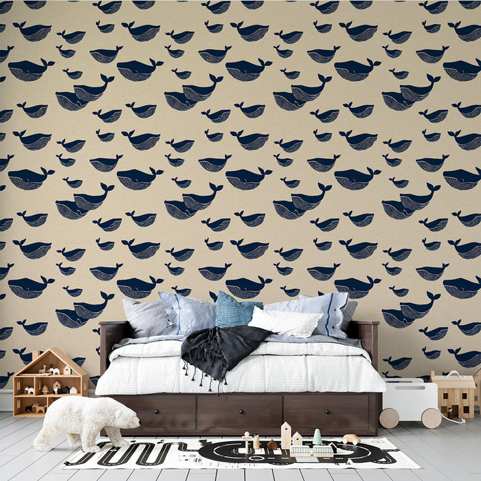Une chambre enfantine avec un papier peint illustrant des baleines stylisées en bleu marine sur un fond beige, créant une atmosphère ludique et apaisante.