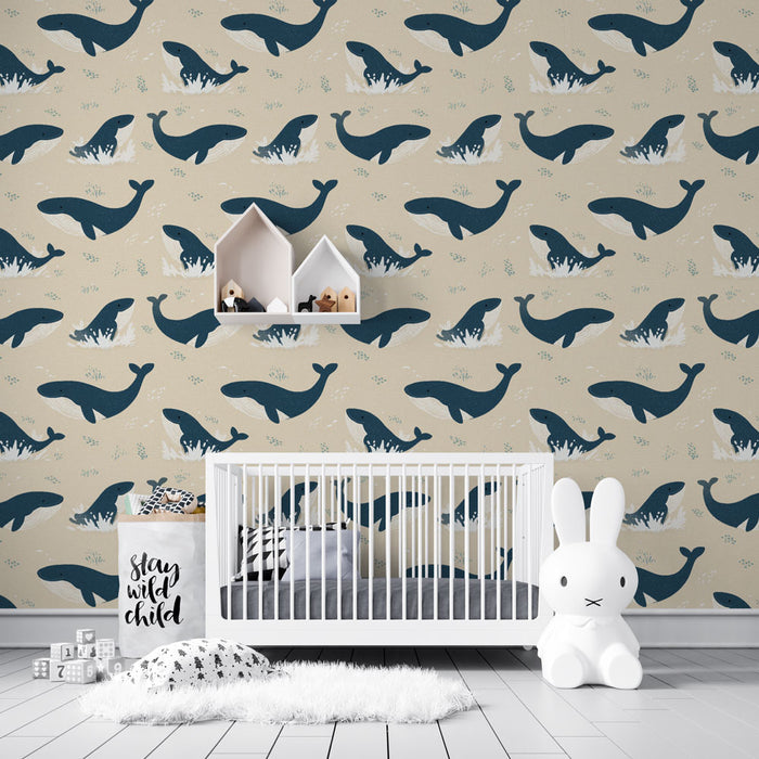 Une chambre d'enfant avec un papier peint illustré de baleines stylisées sur fond beige, créant une atmosphère ludique et apaisante.