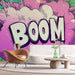 Un salon contemporain avec un papier peint pop art aux couleurs vives, affichant le mot "BOOM" sur fond rose, créant une ambiance dynamique et ludique.