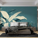 Une chambre moderne avec un papier peint tropical bleu-vert illustrant de grandes feuilles blanches et vertes, créant une atmosphère apaisante et naturelle.