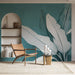 Une pièce moderne avec un papier peint tropical bleu-vert illustrant de grandes feuilles blanches, créant une ambiance apaisante et naturelle.