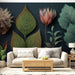 Un salon moderne avec un papier peint botanique aux grandes feuilles et fleurs stylisées sur fond noir, créant une ambiance élégante et apaisante.