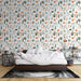 Une chambre apaisante avec un papier peint botanique aux motifs colorés de plantes vertes et fleurs orange sur fond blanc.