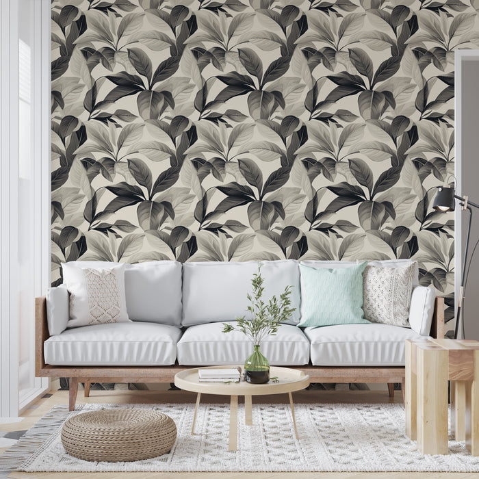 Un salon moderne avec un papier peint aux motifs de feuilles stylisées en noir et blanc sur fond beige, créant une atmosphère élégante et apaisante.
