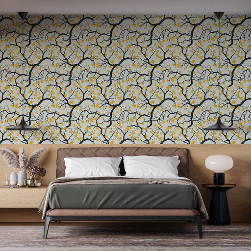 Une chambre moderne avec un papier peint aux motifs de branches noires et fleurs jaunes sur fond clair, créant une ambiance chaleureuse et accueillante.