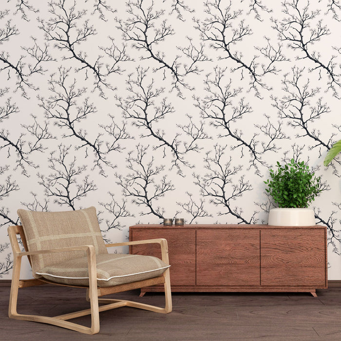 Une pièce moderne avec un papier peint représentant des branches noires sur fond clair, créant une ambiance élégante et apaisante.