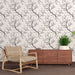 Une pièce moderne avec un papier peint représentant des branches noires sur fond clair, créant une ambiance élégante et apaisante.